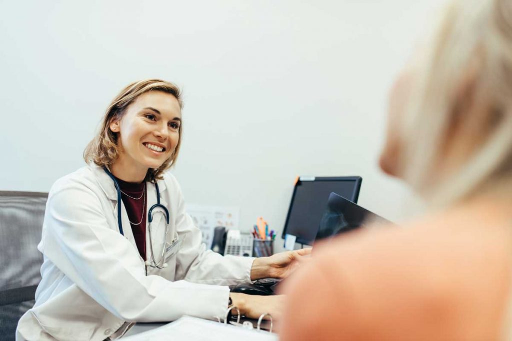 A female doctor talks with a patient.